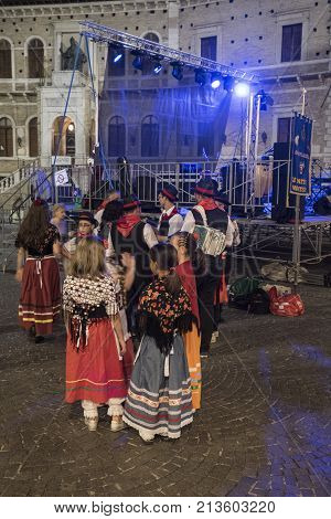 FERMO, ITALY - JULY 9, 2017: Fermo (Marches Italy): historic buildings along the historic main square of the city at evening. People with traditional clothes