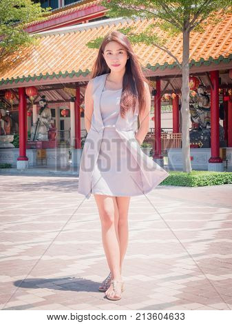 The girl standing in the temple wearing dressed indigo color with courtesy.
