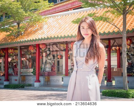 The girl standing in the temple wearing dressed indigo color with courtesy.