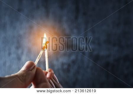One match sets the other on fire. Fire from matches on a dark blue background. The concept of support leadership. Photo with copy space.