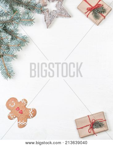 Christmas frame with gifts fir tree branches xmas holiday decorations festive symbols on white wooden background with copyspace. Christmas composition.