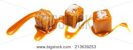 Caramel candies and caramel sauce isolated on a white background. Golden Butterscotch toffee candy