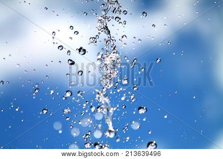 Fountain water splashing. Abstract colorful  background with water splatter. Drops falling in the air.