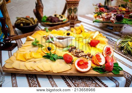 Fresh fruits and berries of different bright colors cut in small pieces are served on a table