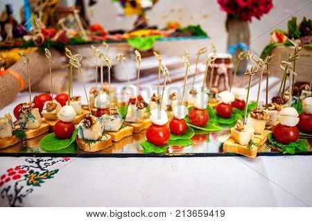 Fresh fruits and berries of different bright colors cut in small pieces are served on a table