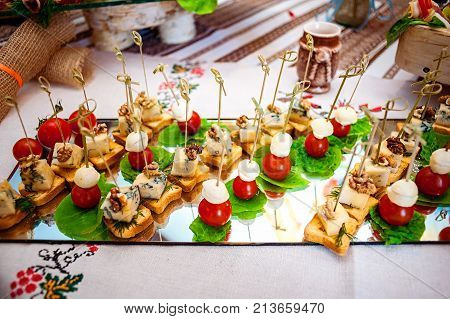 Fresh fruits and berries of different bright colors cut in small pieces are served on a table