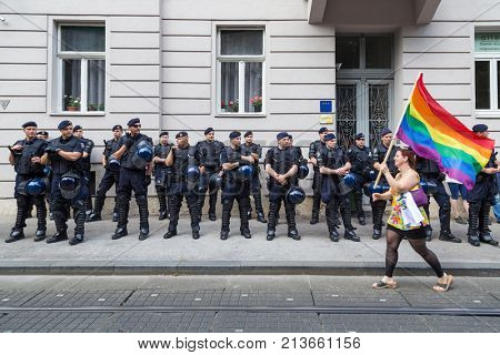ZAGREB, CROATIA - JUNE 11, 2016: 15th Zagreb pride. LGBTIQ activist passing by police cordon holding rainbow flag.