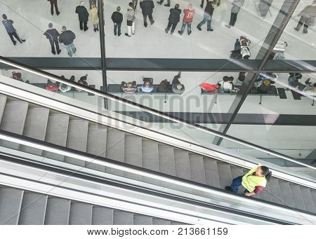 ZAGREB AIRPORT - 24 APRIL 2017: Aerial view of passengers waiting in hall, escalators passing.