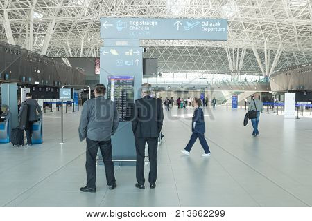 ZAGREB AIRPORT - 24 APRIL 2017: Passengers looking at screen at departures terminal.