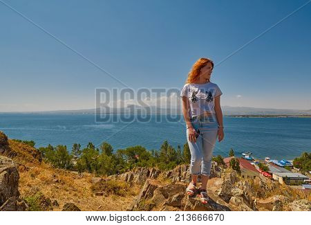 SEVANAVANK MONASTERY, ARMENIA - 02 AUGUST 2017: Young woman near Famous Sevanavank Monastery Landmark on Lake Sevan in Armenia