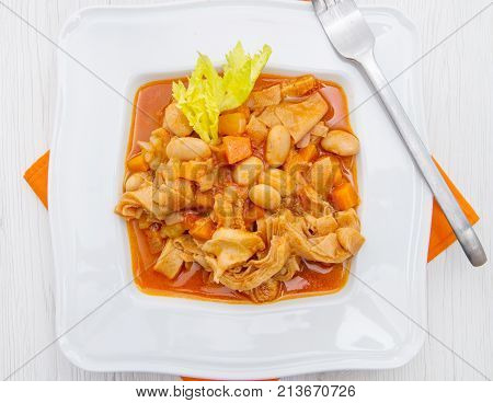 a white dish with trippa and tomatoes sauce