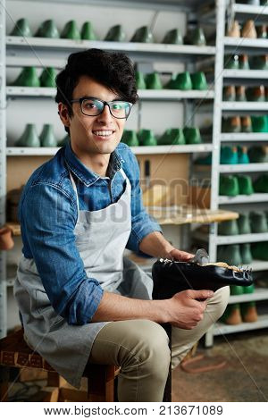 Contemporary cobbler making leather footwear in his workshop