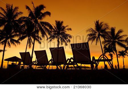 Tumbonas en la playa al atardecer, Tanjung Aru, Malasia en fila.