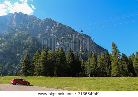 The view of a scenery landscape with green forest mountain massif and cable car in a sunny day. Malga Ciapela Veneto Italy.