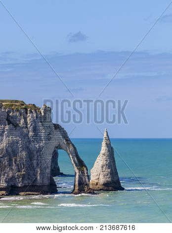 Specific cliffs in Etretat in the Upper-Normandy region in Northern France at low tide: the needle rock and the stone arch.