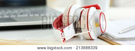 Empty remote office workplace with laptop pc and headset closeup. Receptionist or secretary of contact data center desktop keyboard device desk table ip telephony or callcenter voice message system