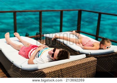 Kids enjoying tropical summer vacation relaxing at overwater villa in luxury resport