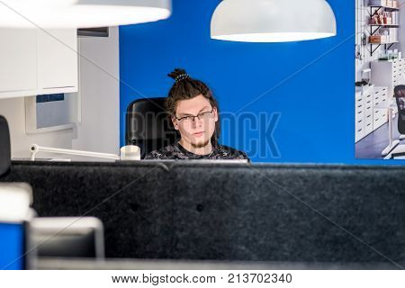 european man with afro hairstyle working with computer in the office. office worker. business concept