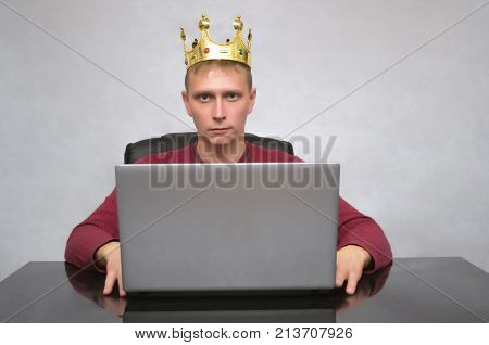 VIP client. Premium user. Success. Smiling happy Business man with golden crown above his head working with laptop computer. Top manager. Smug boss.