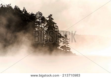 Lake of two rivers in algonquin national park ontario canada sunset sunrise with fog foggy mystical atmosphere background