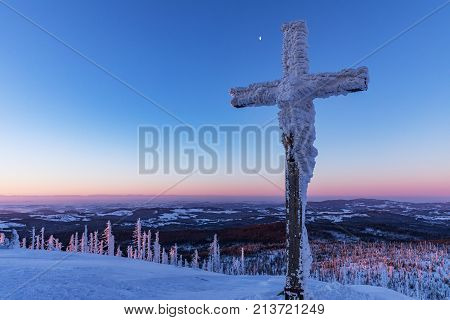 Tourist signpost mountain top Lusen covered by large ice. View of the snowy mountain peaks view from Lusen in Bavaria in the morning sun.