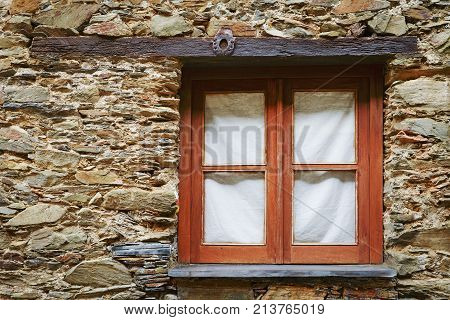 Picturesque wooden window in a wall of a stonework house in Aigra Nova shale village in Gois Portugal