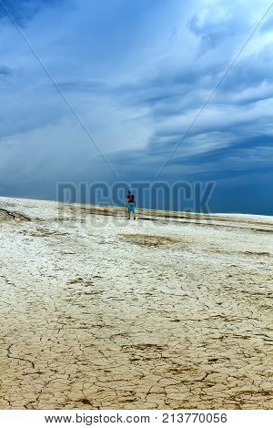 Barren land and stormy skies - woman walking the badlands