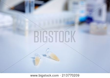 Safe yourself. Small glass ampoules placing on the white table surface and lying next to each other  with medical equipment standing on the background