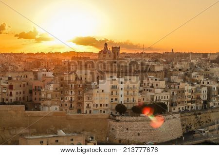malta valletta . capital at sunrise with golden sky, clouds , harbor and boats. Old historical city