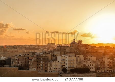 malta valletta . capital at sunrise with golden sky, clouds , harbor and boats. Old historical city