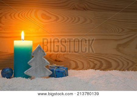 Avent candle and christmas decoration isolated on wood background. Christmas background with snow, candle and wood fir tree.