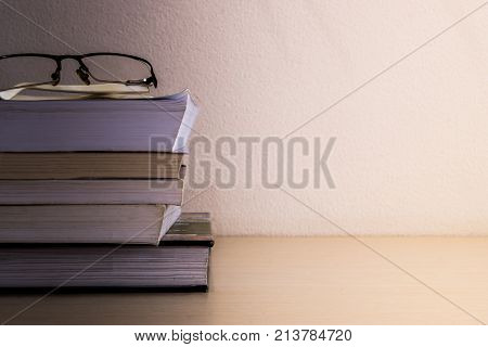 book stacked and glasses on desk after reading
