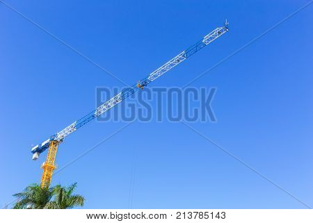construction crain on clear blue sky with space for text