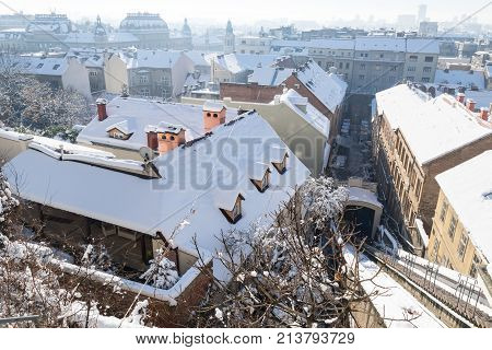 Panorama view over Zagreb with tramrails during winter with snow over the roofs during sunny weather, Zagreb, Croatia, Europe