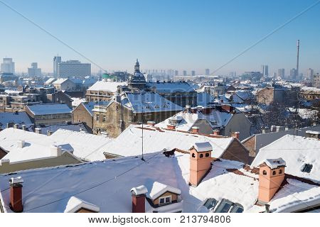 Panorama view over Zagreb with dome and chimneys during winter with snow over the roofs during sunny weather, Zagreb, Croatia, Europe