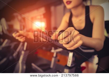 Exercise bike cardio workout at fitness gym of woman taking weight loss with machine aerobic for slim and firm healthy in the morning.
