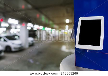 blank digital monitor or tablet on desk at intelligent technology car parking garage area at department store or shopping mall copy space for text or media content marketing advertisement concept