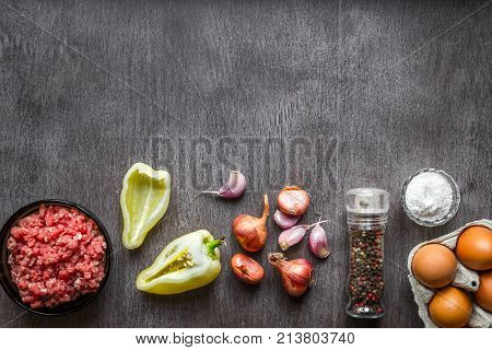 Composition of raw meat with vegetables and spice on wooden background. Top view. Copy space. Still life. Flat lay.