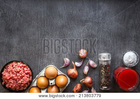 Composition of raw meat with vegetables and spice on wooden background. Top view. Copy space. Still life. Flat lay.