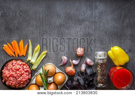 Composition of raw meat with vegetables and spice on wooden background. Top view. Copy space. Still life. Flat lay.