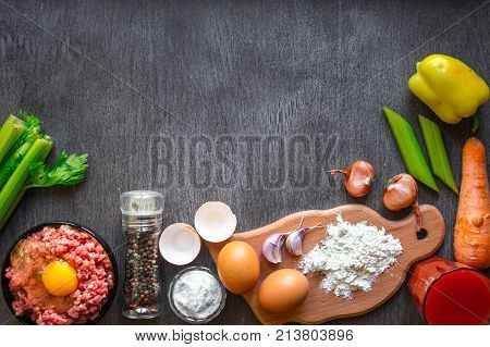 Composition of raw meat with vegetables and spice on wooden background. Top view. Copy space. Still life. Flat lay.