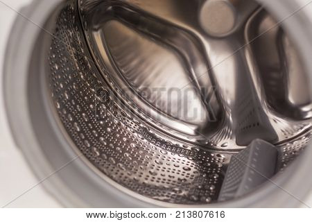 Metallic interior of a modern washer viewed from the oblo