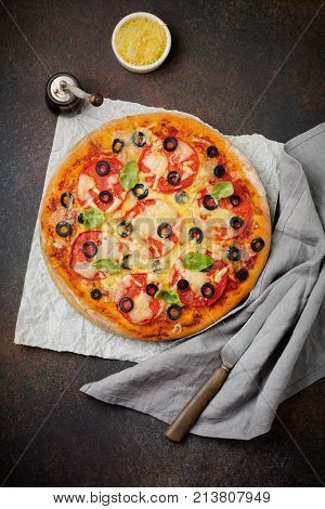 Pizza margarita with tomatoes mazarella and slices of olives on a dark concrete or stone background. Traditional Italian cuisine. Selective focus. Top view.