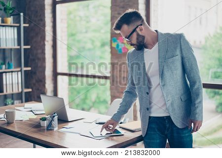 Side Profile Close Up Shot Of Ponder Fashionable Brunet Bearded Lawyer, Looking At The Screen Of Tab