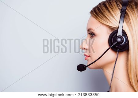 Half Face Side Portrait Of Attractive Blonde Call Center Operator In A Headset. She Is Isolated On A
