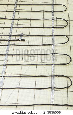 Electric floor heating system installation in new house electric heating cable is installed on the reinforcement grid with the help of mounting tape on the plates of expanded polystyrene
