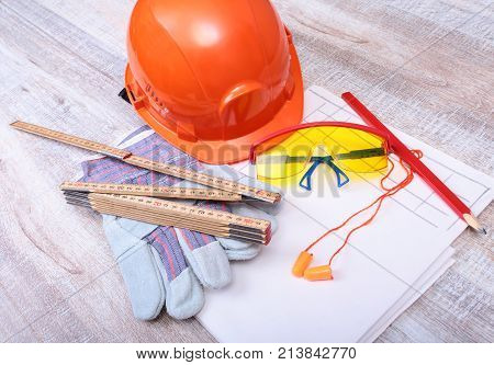 Orange hard hat, earplug, safety glasses and gloves for work. Earplug to reduce noise on a white background