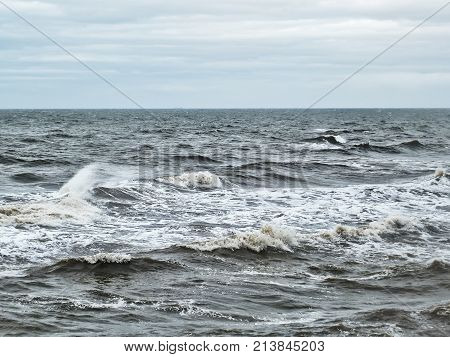 stromy winter atlantic ocean waves in winter with pale sky