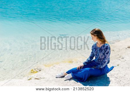 Freedom woman in free happiness bliss on beach. Smiling happy multicultural female model in blue summer dress enjoying serene ocean nature during travel holidays vacation outdoors.
