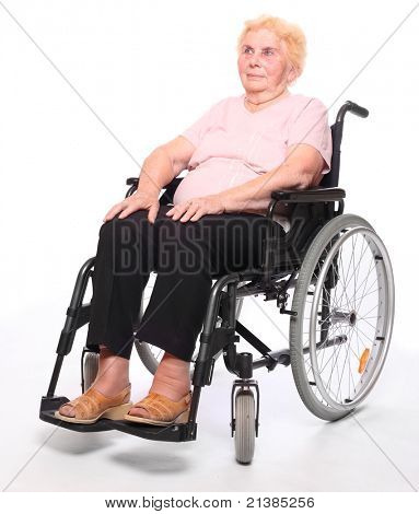 Glückliche ältere gelähmter Frau sitzt in einem Rollstuhl auf einem weißen.